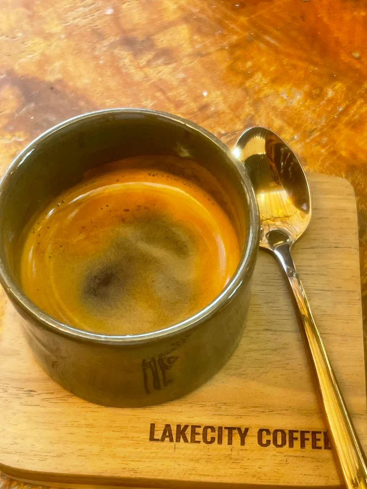Top-down espresso shot in a stoneware cup with a Lakecity Coffee branded coaster