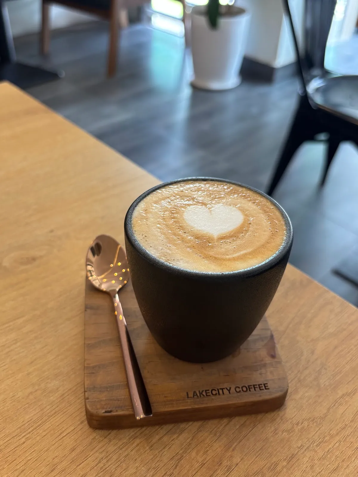 Latte with a heart of micro-foam in a matte black cup